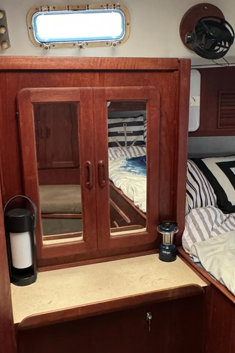 Slide: The Image of Interior of 1981 Morgan 416 Out Island yacht with wooden cabinetry and striped bedding. - 26