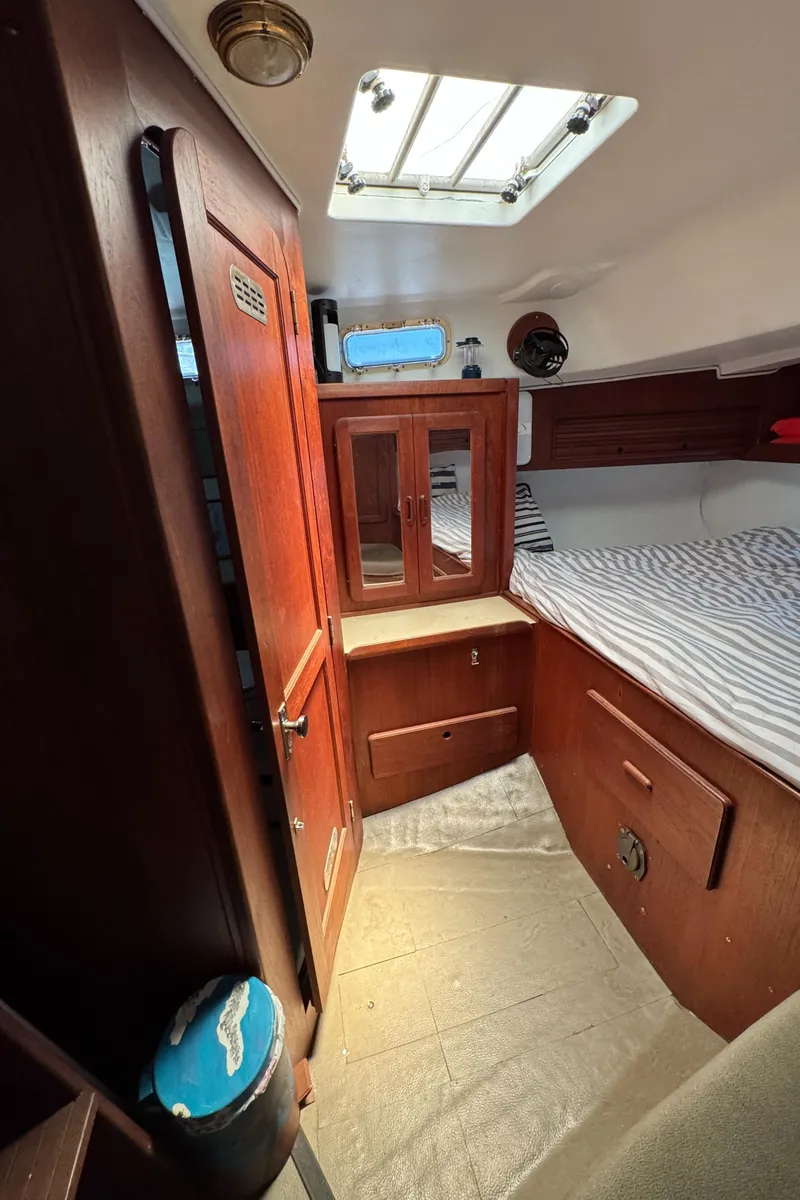Slide: The Image of 1981 Morgan 416 Out Island cabin interior with wood paneling and striped bedding. - 28