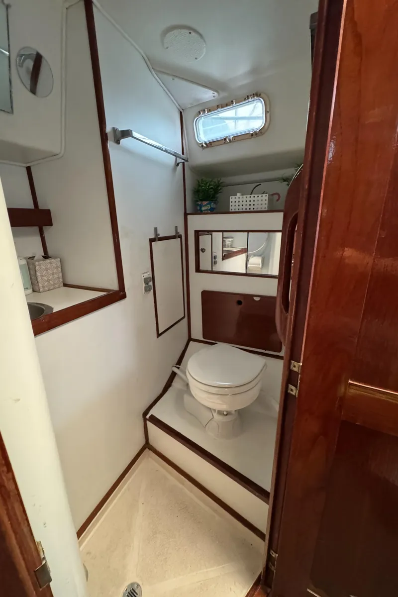Slide: The Image of 1981 Morgan 416 Out Island yacht bathroom with toilet, sink, and wooden accents. - 29
