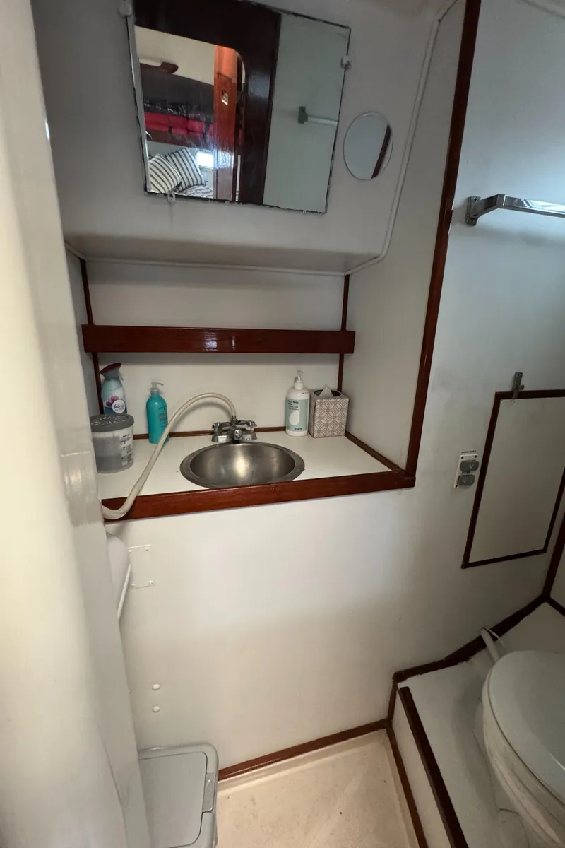 Slide: The Image of 1981 Morgan 416 Out Island yacht bathroom with sink, mirror, and toiletries. - 31