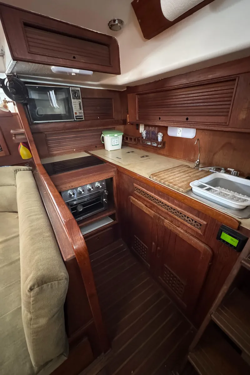 Slide: The Image of 1981 Morgan 416 Out Island yacht interior kitchen with wooden cabinetry and modern appliances. - 8
