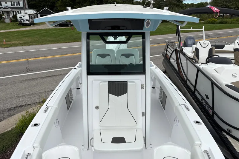 Slide: The Image of 2025 Wellcraft 243 Fisherman boat, white interior, parked near road, showcasing center console. - 3