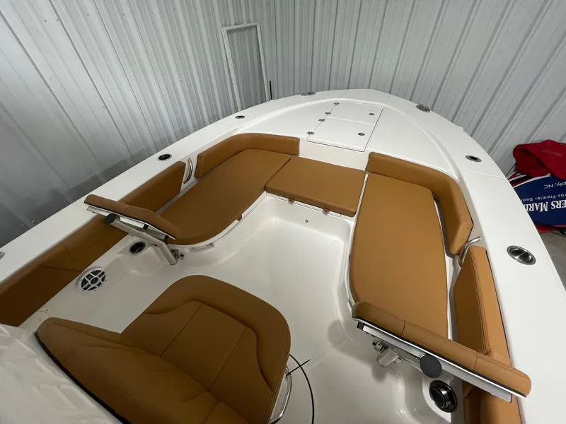 Slide: The Image of 2025 Robalo 246 Cayman boat interior with tan seating and white deck. - 8