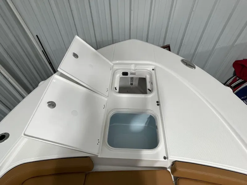 Slide: The Image of 2025 Robalo 246 Cayman boat storage compartments with open lids, showcasing interior features. - 9