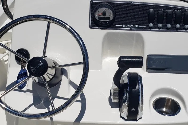 Slide: The Image of 2022 Boston Whaler 170 Montauk steering console with controls and switches. - 17