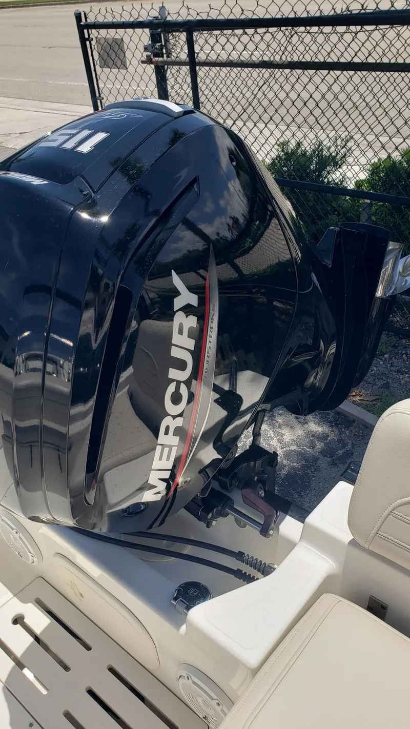 Slide: The Image of 2022 Boston Whaler 170 Montauk with Mercury outboard motor, parked near a fence. - 27