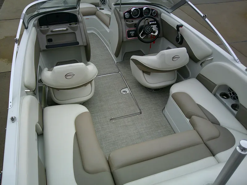 Slide: The Image of 2019 Crownline 19 XS boat interior with beige and white seating, cup holders, and carpeted flooring. - 8