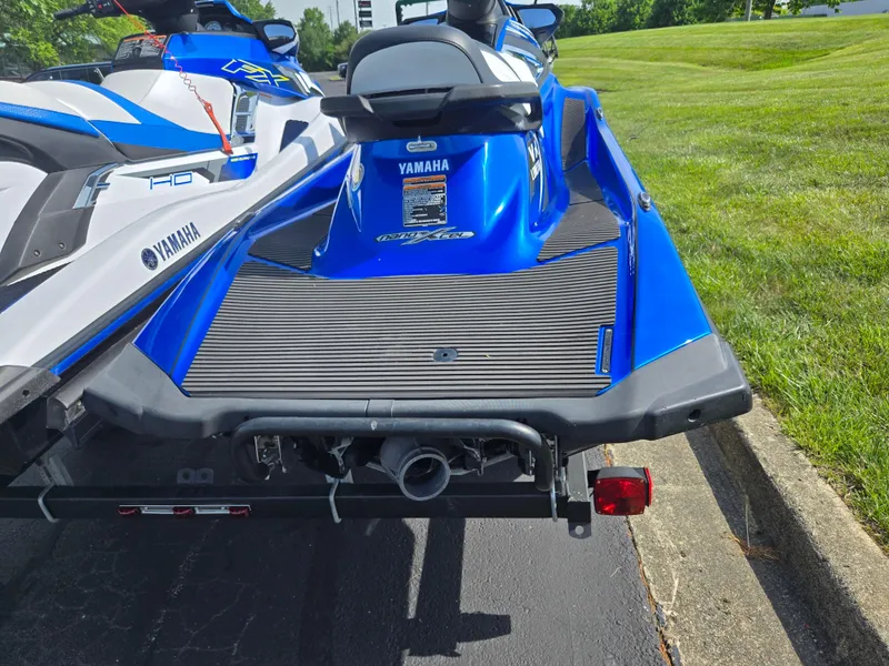 Slide: The Image of 2017 Yamaha WaveRunner VX Limited in blue, parked on pavement near grass. - 2