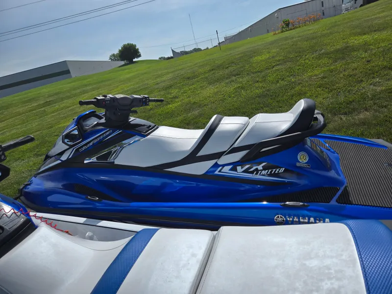 Slide: The Image of 2017 Yamaha WaveRunner VX Limited, blue and white, parked on grass near industrial buildings. - 4