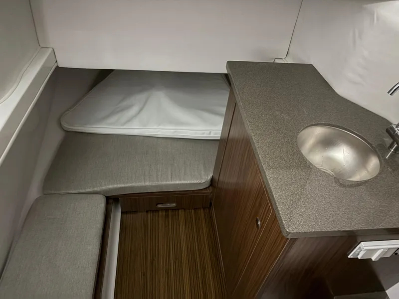 Slide: The Image of 2025 Wellcraft 352 Fisherman cabin interior with sink and cushioned seating. - 10