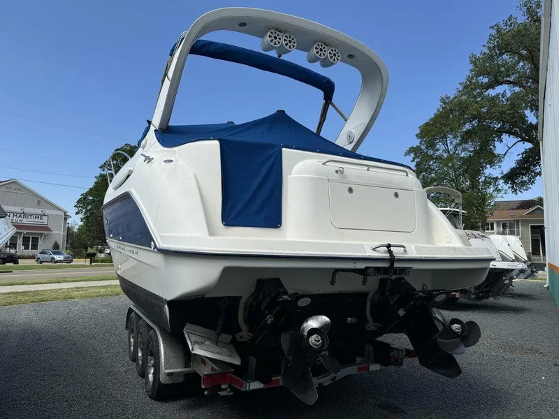 Slide: The Image of 2005 Bayliner 305 boat on trailer, rear view with blue cover, parked outdoors. - 2