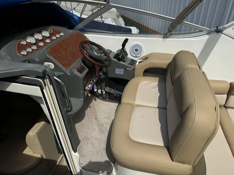 Slide: The Image of 2005 Bayliner 305 boat interior with beige seating and dashboard controls. - 5