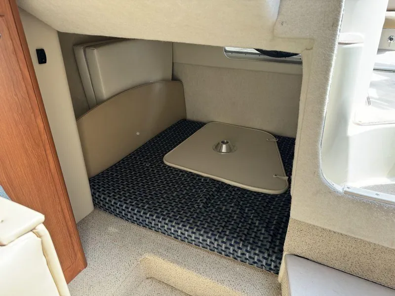Slide: The Image of 2005 Bayliner 305 interior cabin with cushioned seating and table base. - 7