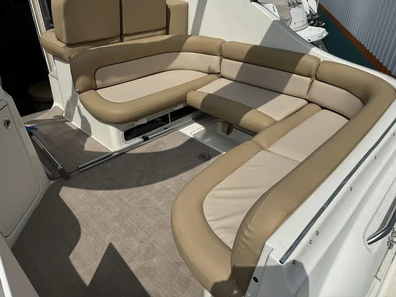 Slide: The Image of 2005 Bayliner 305 boat interior with beige cushioned seating and carpeted flooring. - 9