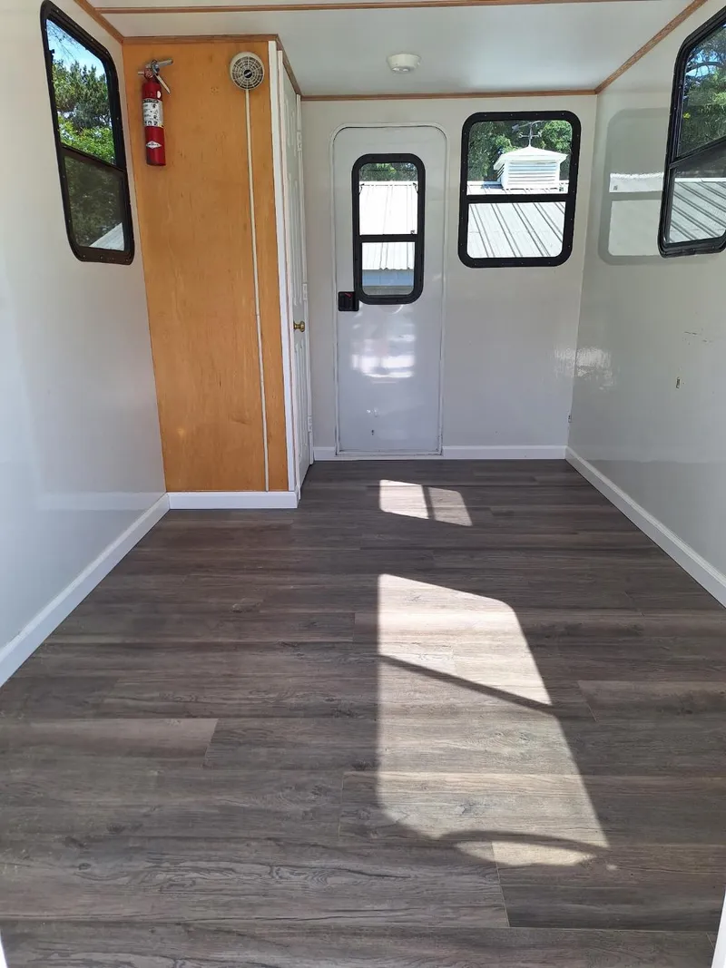 Slide: The Image of Interior of 2010 Custom River Time Houseboat with wood flooring and white walls. - 14