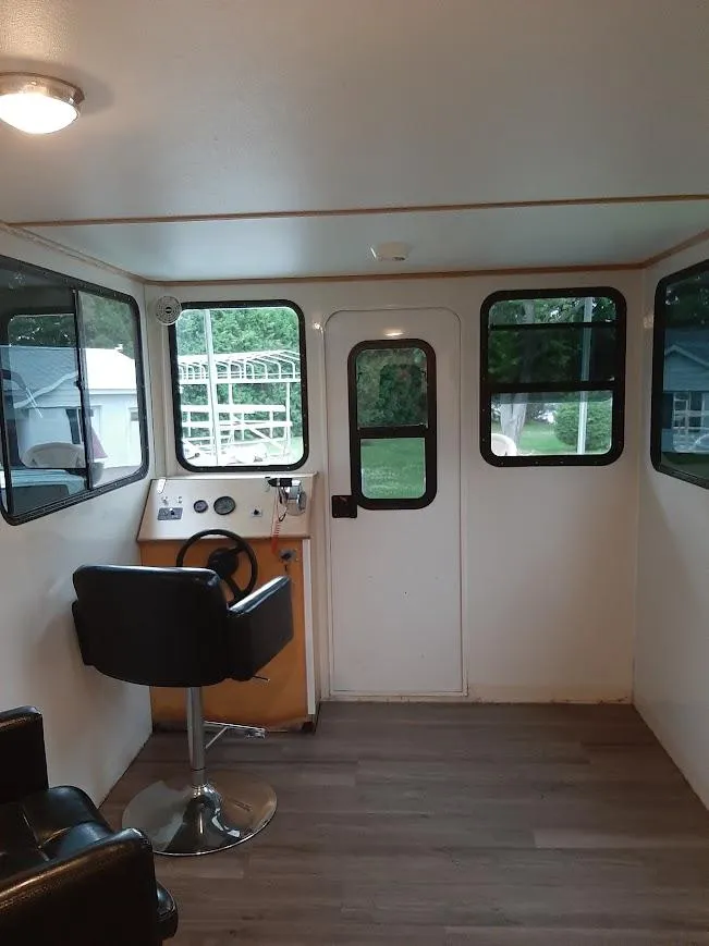 Slide: The Image of Interior of 2010 Custom River Time Houseboat with steering console and seating. - 7