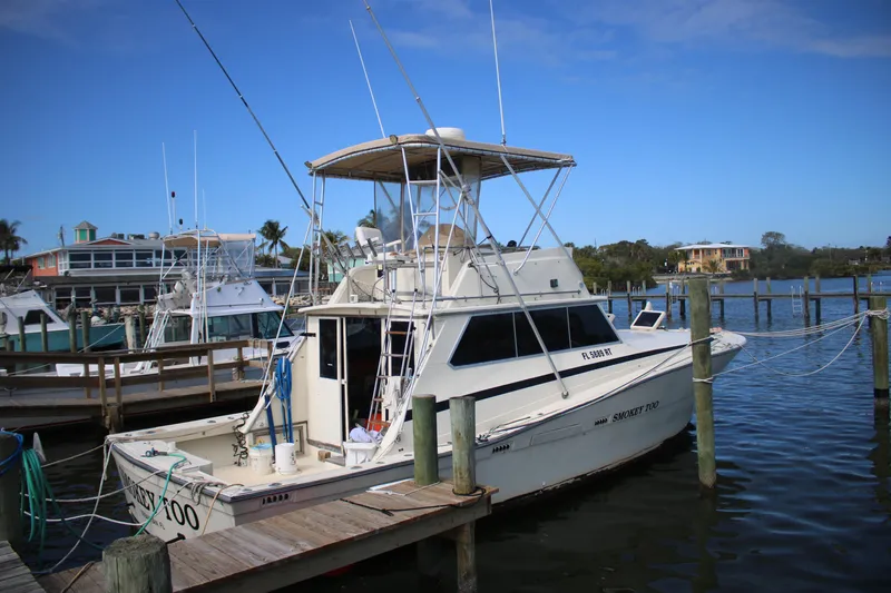 The Image of 1974 Viking Boats 40 Sport Fish docked at marina, clear blue sky background. - 1