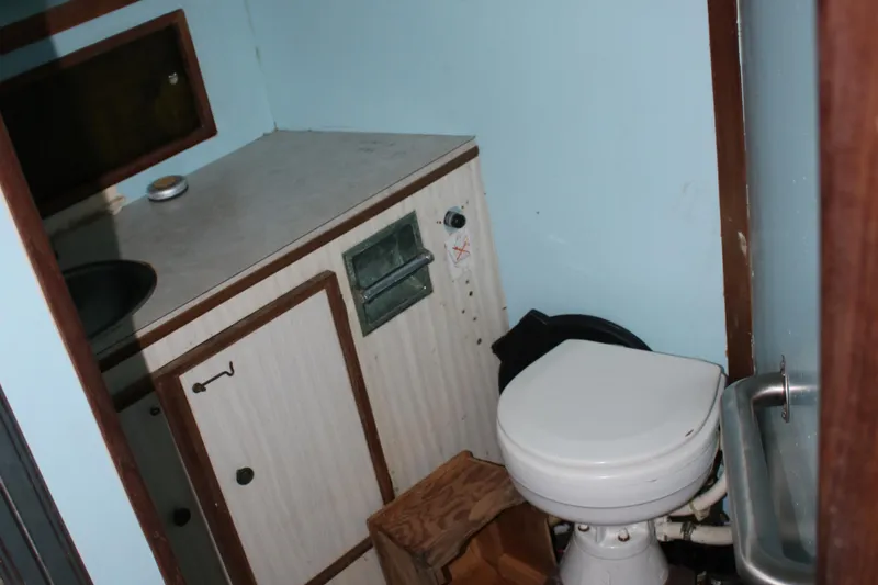 Slide: The Image of 1974 Viking Boats 40 Sport Fish bathroom with toilet, sink, and storage cabinet. - 25