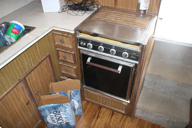 Slide: The Image of 1974 Viking Boats 40 Sport Fish kitchen with vintage stove and wooden cabinetry. - 7