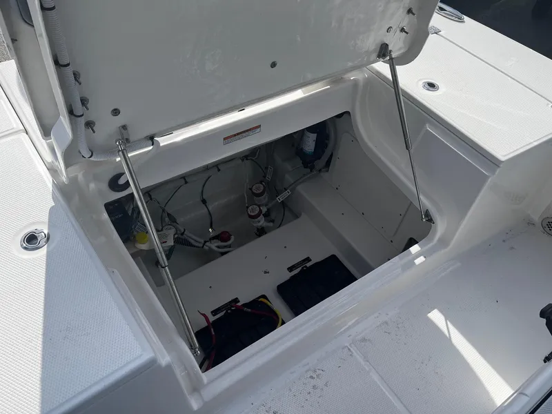 Slide: The Image of Open storage compartment of 2025 Robalo 246 Cayman boat, showing internal components. - 11