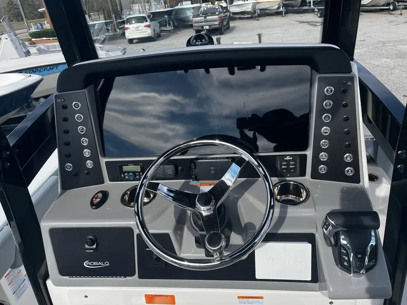Slide: The Image of 2025 Robalo 246 Cayman boat dashboard with steering wheel and control panel. - 13