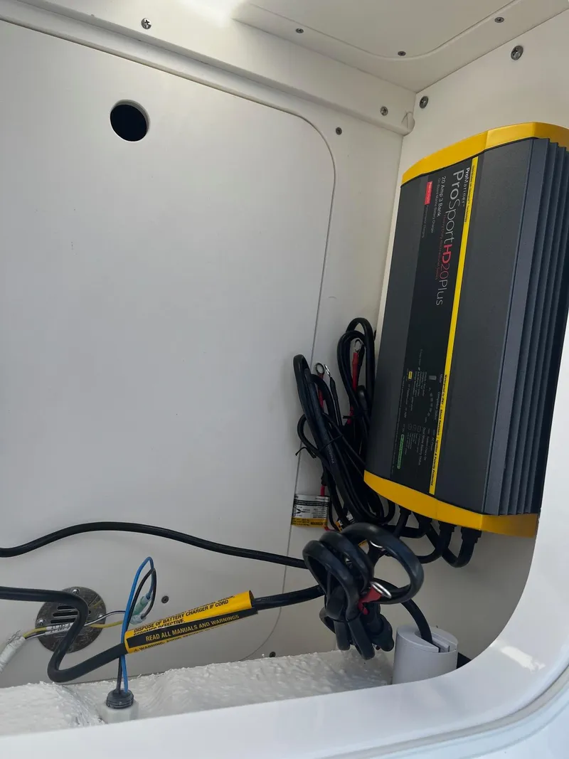 Slide: The Image of Battery charger installed in a 2025 Robalo 246 Cayman boat compartment. - 20