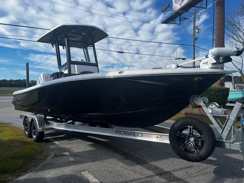 Slide: The Image of 2025 Robalo 246 Cayman boat on trailer under blue sky. - 5