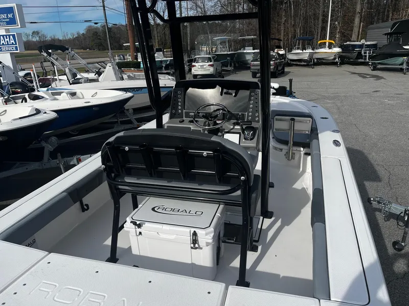 Slide: The Image of 2025 Robalo 246 Cayman boat interior with steering console and seating, displayed at a dealership. - 8
