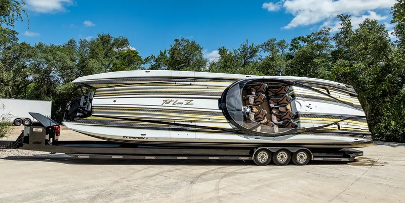 The Image of 2017 MTI 48 speedboat on trailer, vibrant design, parked outdoors. - 0