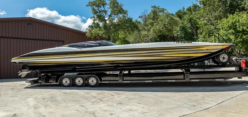 Slide: The Image of 2017 MTI 48 speedboat on trailer, sleek design with black and yellow stripes. - 13
