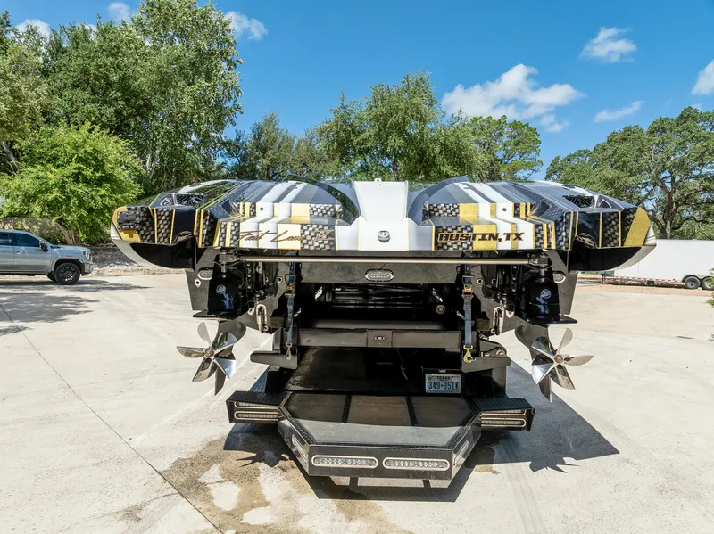 Slide: The Image of 2017 MTI 48 boat with dual propellers, parked outdoors under a clear blue sky. - 21