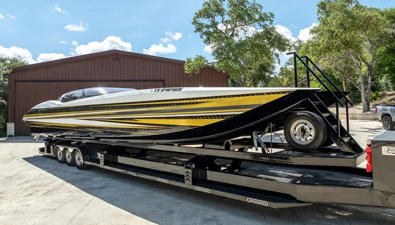 Slide: The Image of 2017 MTI 48 speedboat on trailer, featuring sleek yellow and black design, parked outdoors. - 26