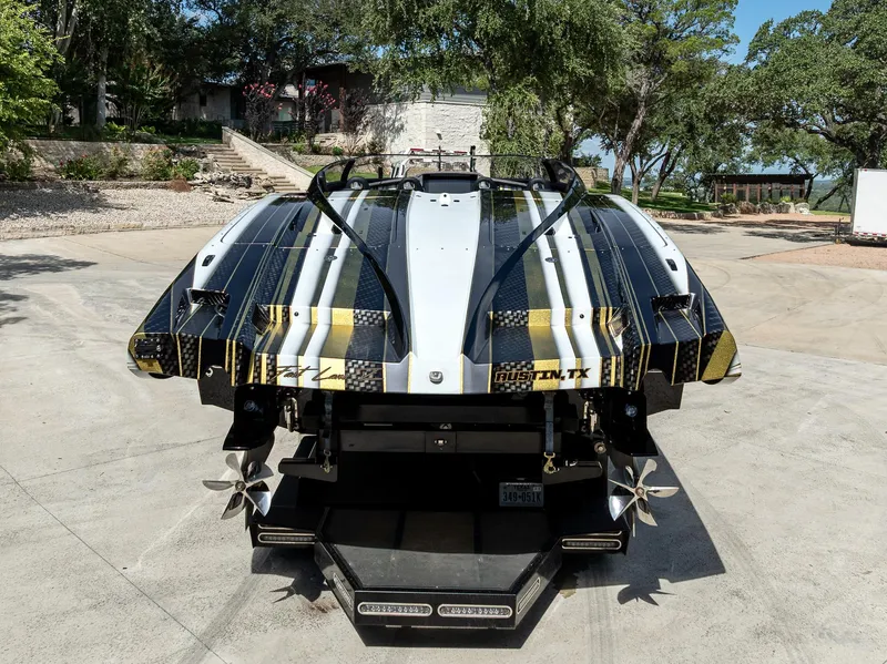 Slide: The Image of Rear view of a 2017 MTI 48 speedboat with custom graphics, parked outdoors. - 28