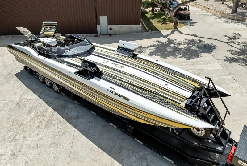 Slide: The Image of 2017 MTI 48 speedboat with sleek yellow and black stripes on a trailer. - 3