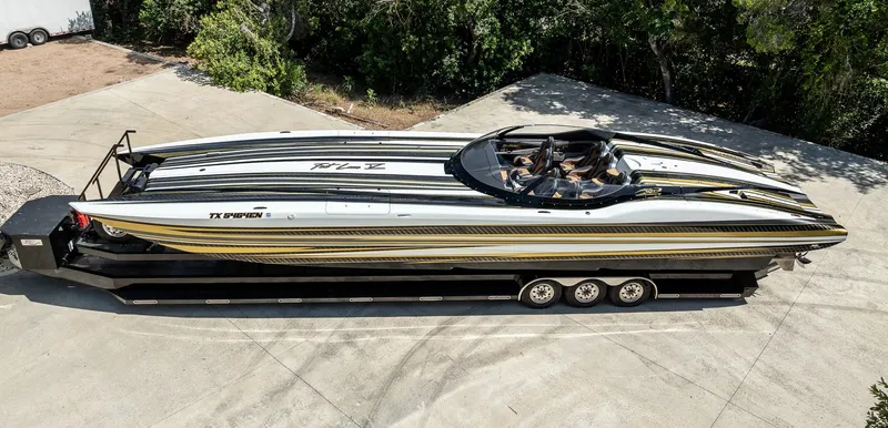 Slide: The Image of 2017 MTI 48 speedboat on trailer, sleek design with black and gold accents. - 30