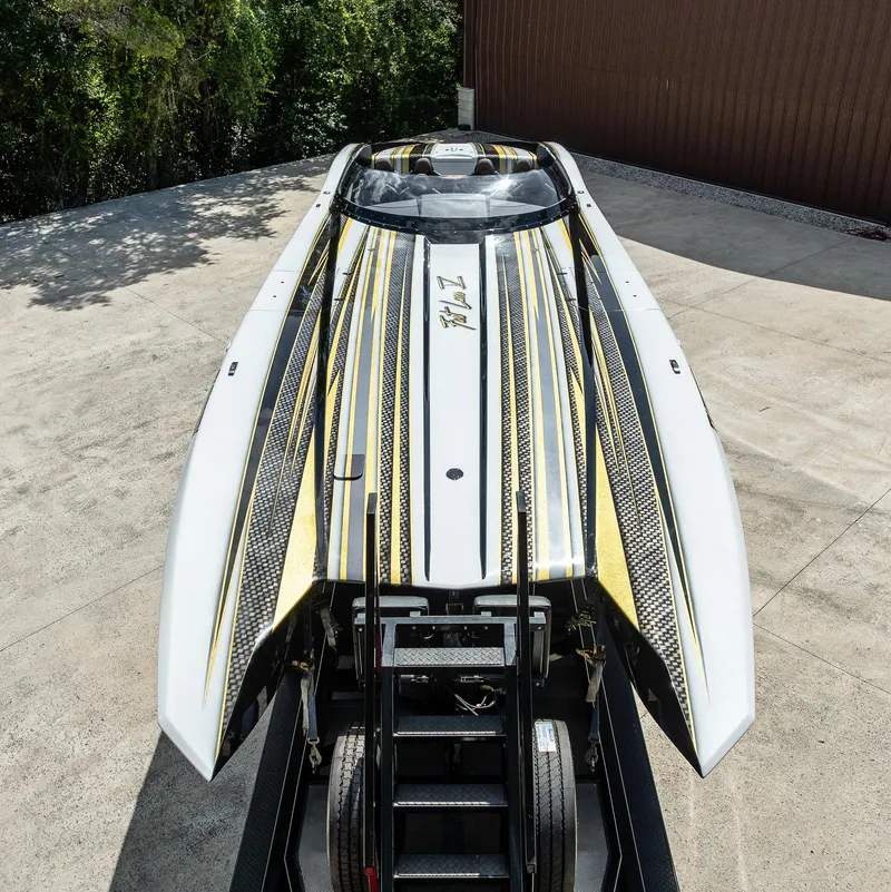 Slide: The Image of 2017 MTI 48 powerboat with sleek black and yellow design on a trailer. - 32