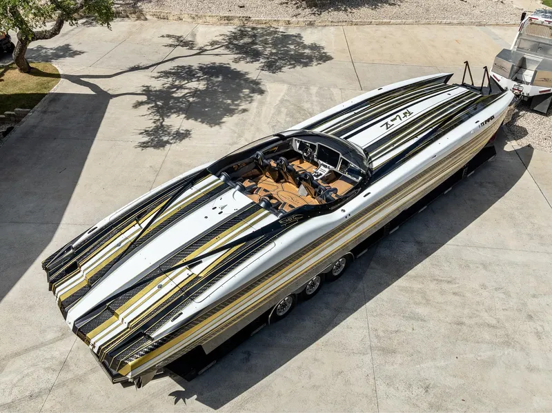Slide: The Image of 2017 MTI 48 speedboat with sleek black, white, and gold design on a trailer. - 36