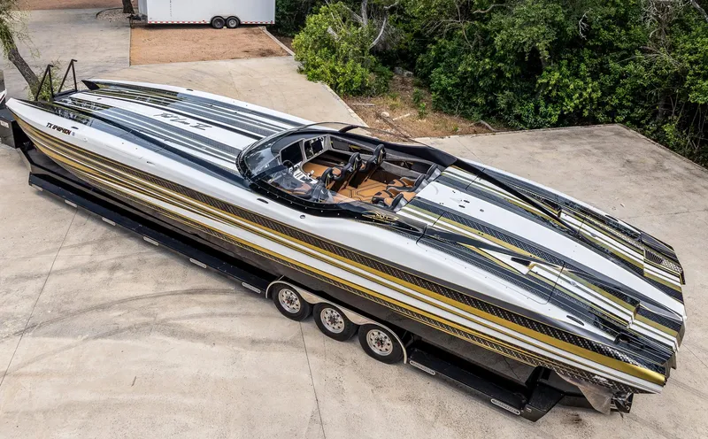 Slide: The Image of 2017 MTI 48 powerboat on trailer, sleek design with black and gold accents. - 38