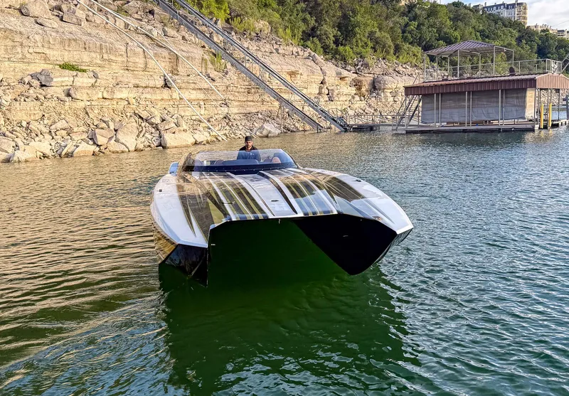 Slide: The Image of 2017 MTI 48 speedboat on a lake near rocky shoreline and dock. - 7