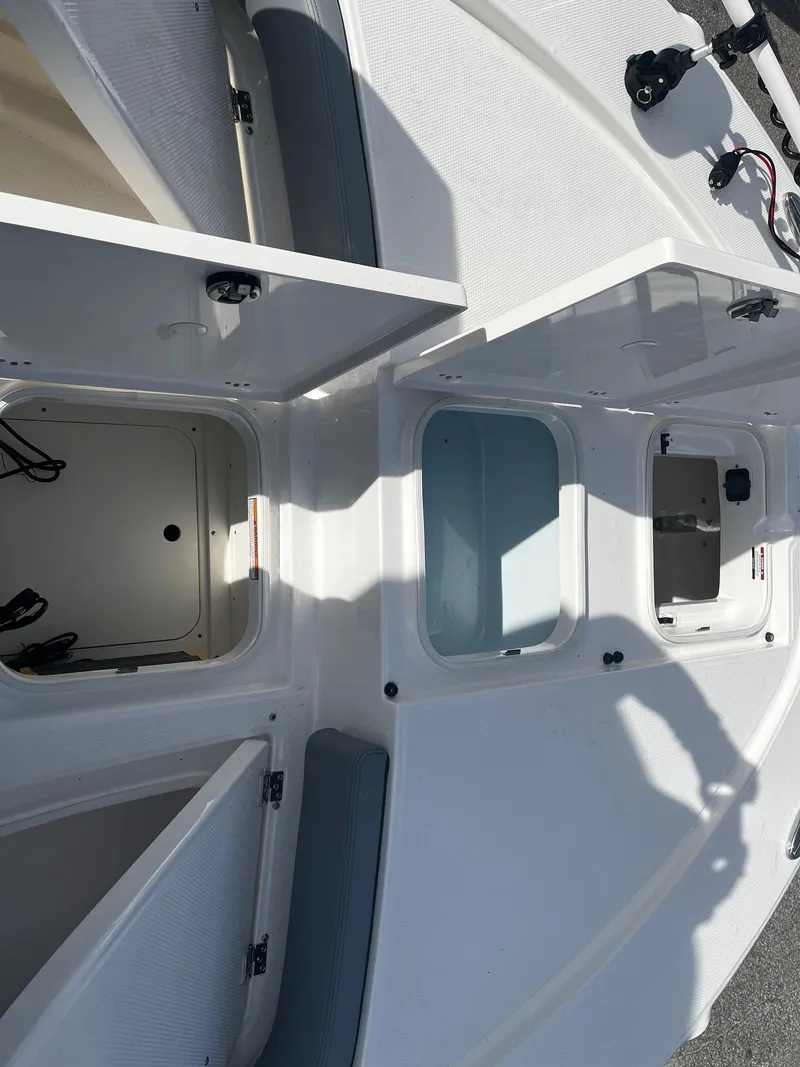 Slide: The Image of 2025 Robalo 246 Cayman boat storage compartments open, showcasing interior features. - 19
