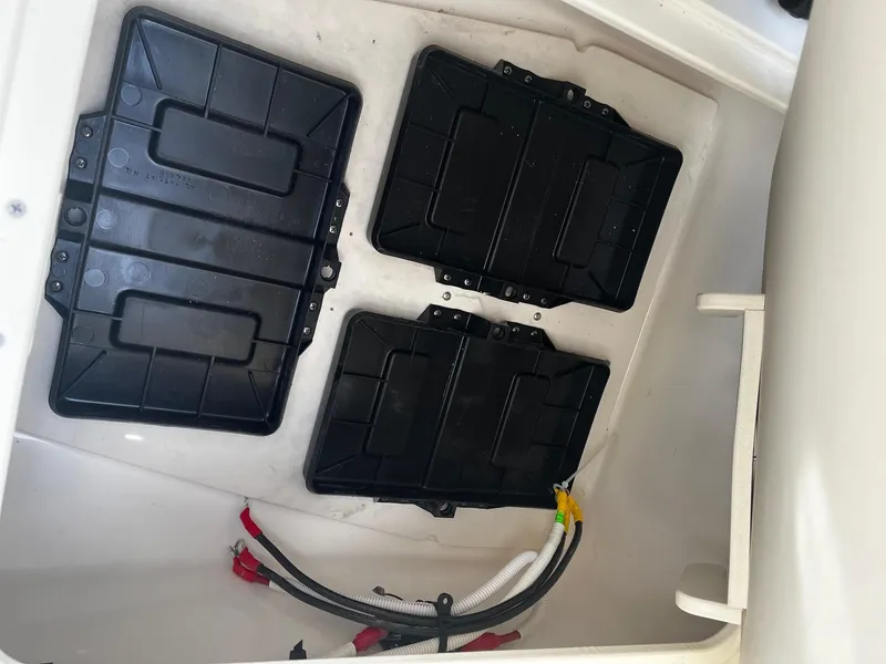 Slide: The Image of Battery compartment of 2025 Robalo 246 Cayman boat with wiring and covers. - 21