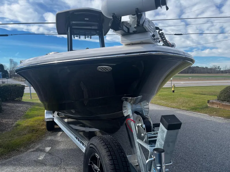 Slide: The Image of 2025 Robalo 246 Cayman boat on trailer, parked outdoors under a blue sky. - 6