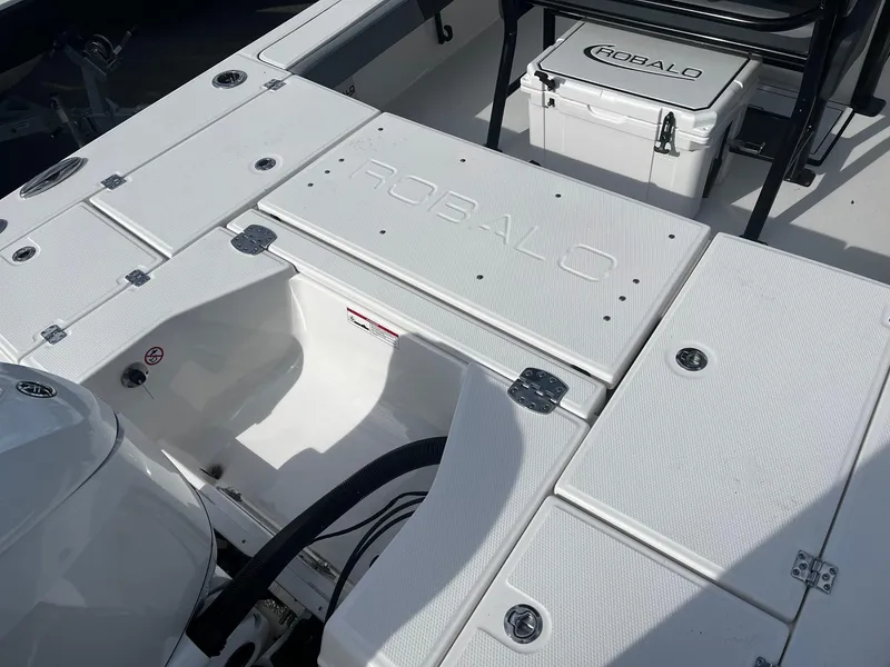 Slide: The Image of 2025 Robalo 246 Cayman boat deck with storage compartments and cooler. - 7
