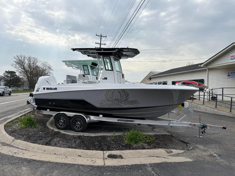 The Image of 2025 Wellcraft 223 Fisherman boat on trailer, parked outdoors under cloudy sky. - 0