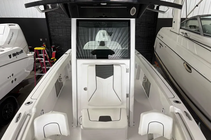 Slide: The Image of 2025 Wellcraft 223 Fisherman boat interior with seating and console, in showroom. - 10