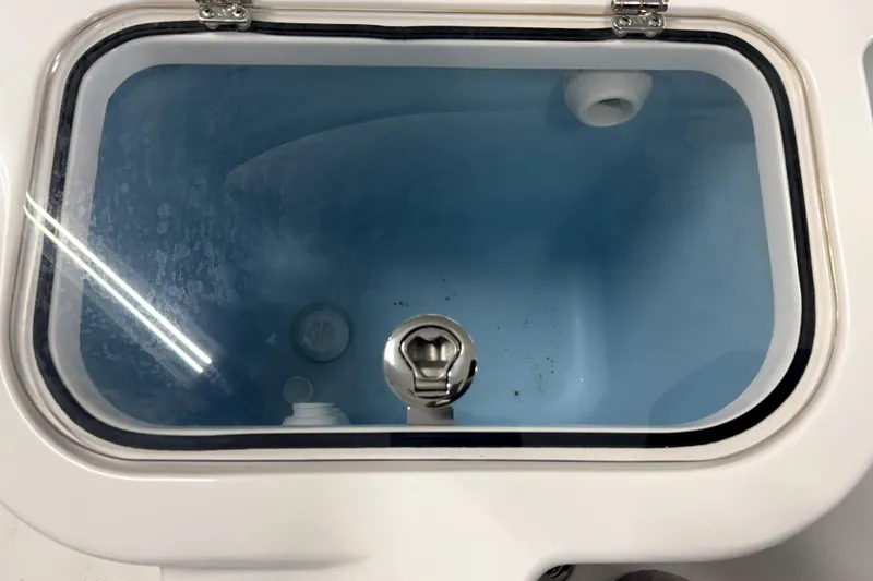 Slide: The Image of Livewell compartment on 2025 Wellcraft 223 Fisherman boat, featuring a secure latch. - 12