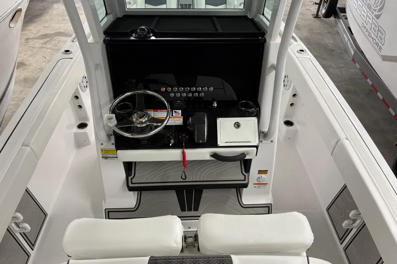 Slide: The Image of 2025 Wellcraft 223 Fisherman boat cockpit with steering wheel and control panel. - 3