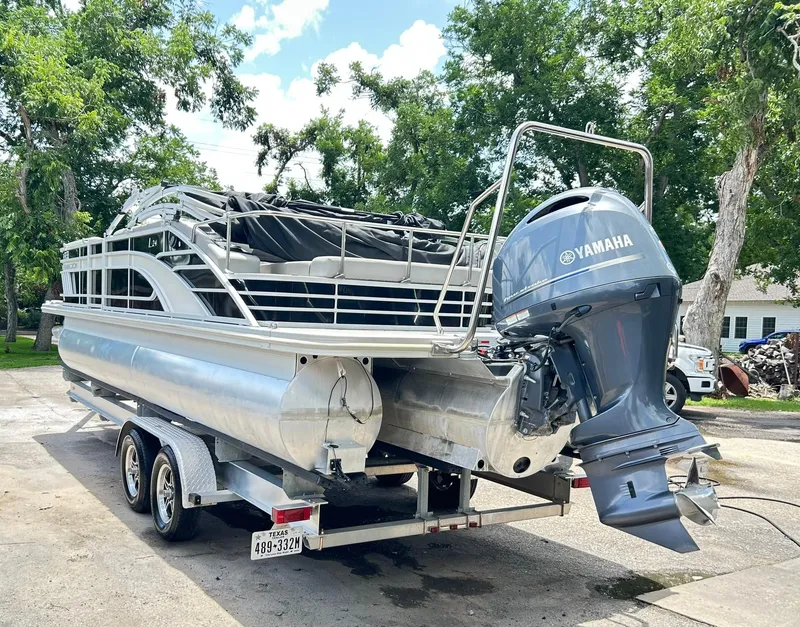 The Image of 2021 Bennington L 24 Swingback pontoon boat with Yamaha outboard motor on trailer. - 0