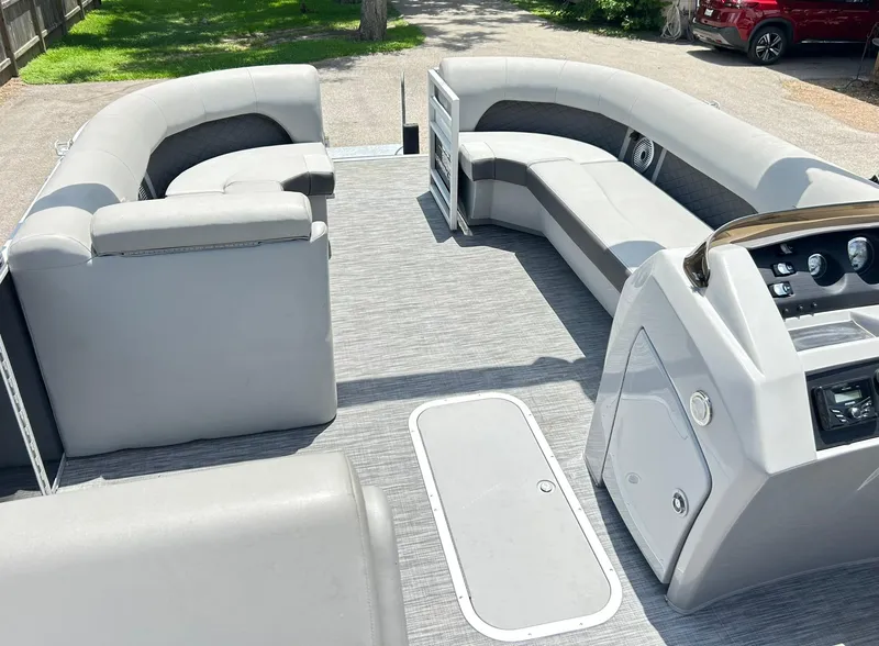 Slide: The Image of 2021 Bennington L 24 Swingback pontoon boat interior with gray seating and control panel. - 24