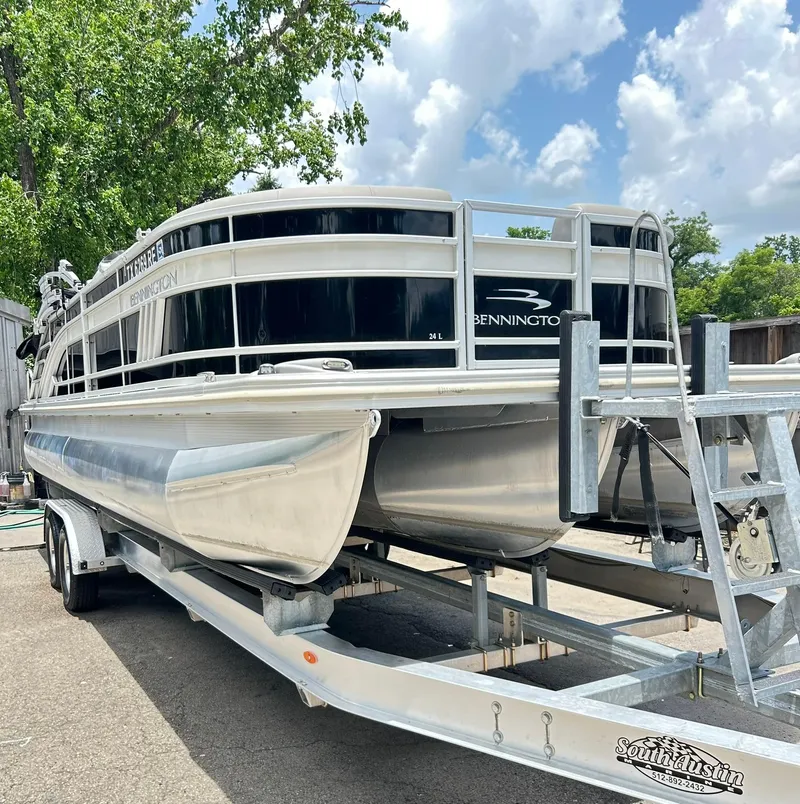 Slide: The Image of 2021 Bennington L 24 Swingback pontoon boat on trailer, parked outdoors. - 3
